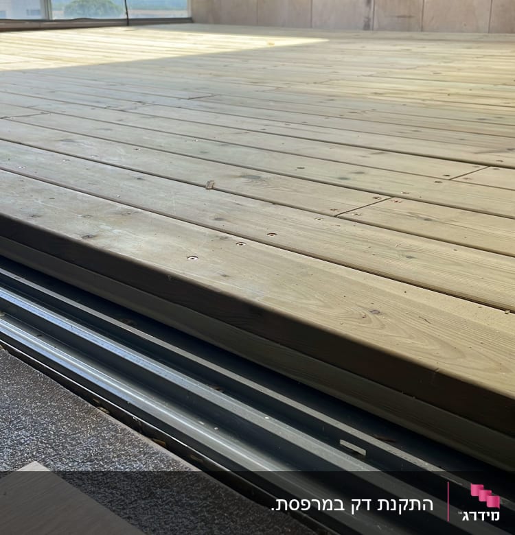 רצפת עץ על מרפסת עם מעקה זכוכית